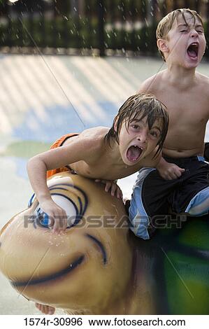 Stock Photograph - Portrait of boys shouting on a tortoise sculpture. Fotosearch