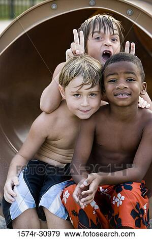 Portrait of boys sitting together at end of a slide View Large Photo Image Stock Photo - Portrait of boys sitting together at end of a slide. Fotosearch