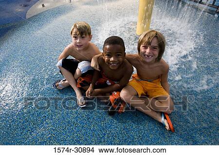 Portrait of boys sitting under a shower View Large Photo Image Picture - Portrait of boys sitting under a shower. Fotosearch