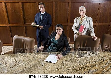 Portrait of business people by conference table in an office View Large Photo Image Stock Photo - Portrait of business people by conference table in an office. Fotosearch