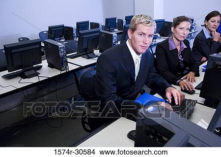 Portrait of business people using desktop pc in an office View Large Photo Image Picture - Portrait of business people using desktop pc in an office. Fotosearch