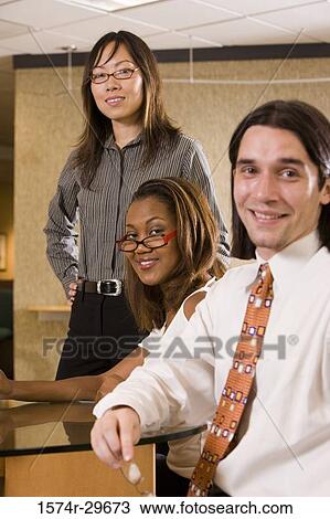 Portrait of businessman and businesswomen sitting in office View Large Photo Image Stock Image - Portrait of businessman and businesswomen sitting in office. Fotosearch