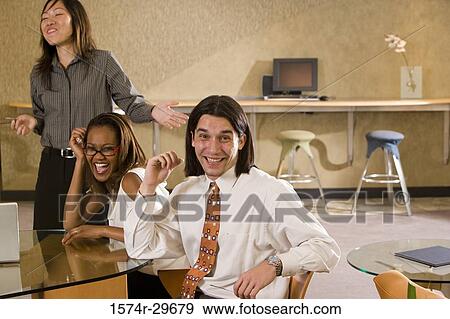 Portrait of businessman and businesswomen sitting in office View Large Photo Image Stock Photo - Portrait of businessman and businesswomen sitting in office. Fotosearch
