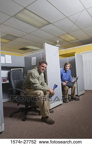 Stock Image - Portrait of businessmen sitting in an office. Fotosearch