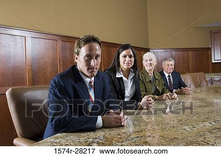 Portrait of cheerful business people sitting by conference table in an office View Large Photo Image Stock Photo - Portrait of cheerful business people sitting by conference table in an office. Fotosearch