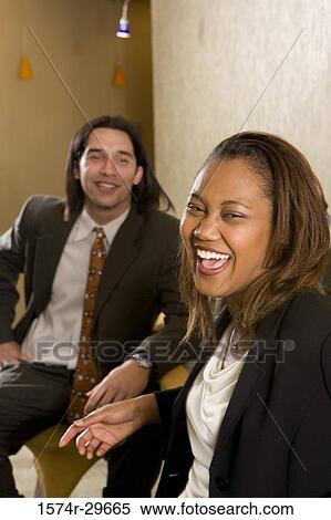 Stock Photography - Portrait of cheerful businessmen and businesswoman sitting in an office. Fotosearch