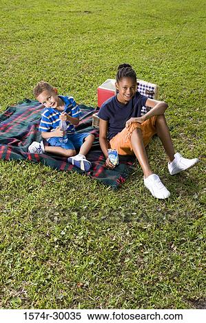 Portrait of cheerful children sitting on blanket at park View Large Photo Image Stock Photography - Portrait of cheerful children sitting on blanket at park. Fotosearch