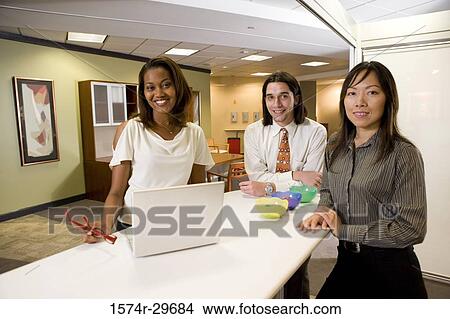 Picture - Portrait of cheerful colleagues standing together in an office. Fotosearch