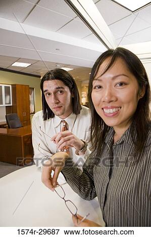 Portrait of cheerful colleagues standing in the office View Large Photo Image Stock Photo - Portrait of cheerful colleagues standing in the office. Fotosearch