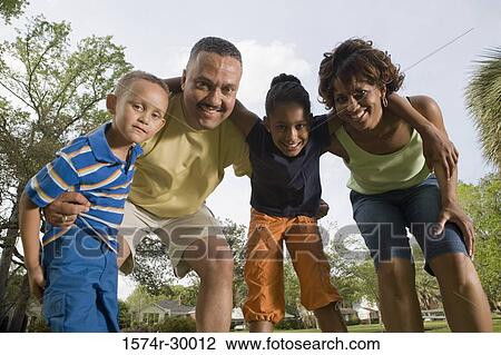 Portrait of cheerful family standing at park View Large Photo Image Stock Image - Portrait of cheerful family standing at park. Fotosearch