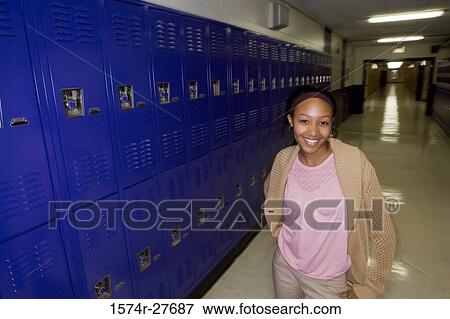 Portrait of cheerful female student standing by lockers View Large Photo Image Stock Photo - Portrait of cheerful female student standing by lockers. Fotosearch