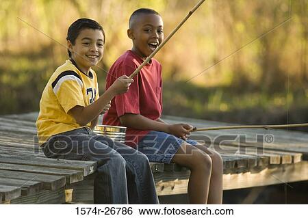 Portrait of cheerful friends fishing with fishing rods while sitting on the jetty View Large Photo Image Stock Photograph - Portrait of cheerful friends fishing with fishing rods while sitting on the jetty. Fotosearch