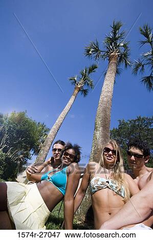 Portrait of cheerful friends relaxing on lawn View Large Photo Image Stock Photo - Portrait of cheerful friends relaxing on lawn. Fotosearch
