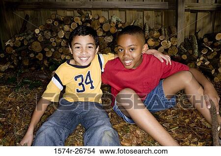 Portrait of cheerful friends sitting by logs View Large Photo Image Picture - Portrait of cheerful friends sitting by logs. Fotosearch
