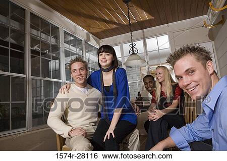 Portrait of cheerful friends sitting in dining room View Large Photo Image Stock Photograph - Portrait of cheerful friends sitting in dining room. Fotosearch