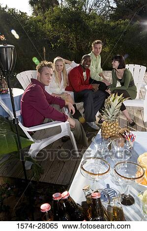 Portrait of cheerful friends sitting on armchairs on wooden deck View Large Photo Image Stock Photography - Portrait of cheerful friends sitting on armchairs on wooden deck. Fotosearch
