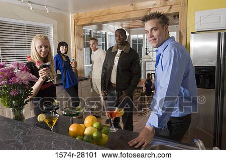 Portrait of cheerful friends standing with wines in domestic kitchen View Large Photo Image Stock Image - Portrait of cheerful friends standing with wines in domestic kitchen. Fotosearch