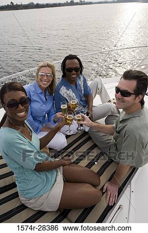 Portrait of cheerful friends toasting champagne on the deck of a boat View Large Photo Image Stock Photograph - Portrait of cheerful friends toasting champagne on the deck of a boat. Fotosearch