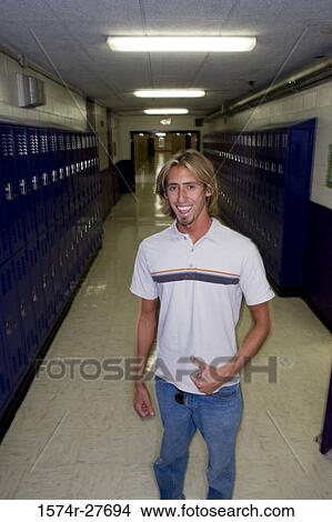 Portrait of cheerful male student standing by lockers View Large Photo Image Picture - Portrait of cheerful male student standing by lockers. Fotosearch