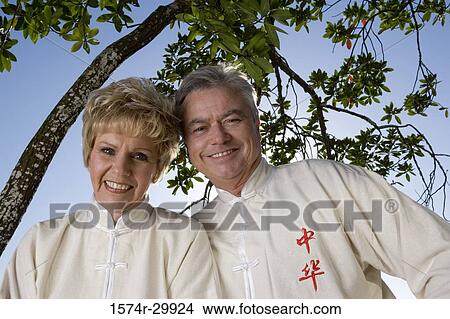 Portrait of cheerful mature couple wearing sports clothing View Large Photo Image Picture - Portrait of cheerful mature couple wearing sports clothing. Fotosearch