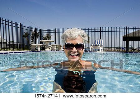 Portrait of cheerful senior woman in swimming pool View Large Photo Image Stock Image - Portrait of cheerful senior woman in swimming pool. Fotosearch