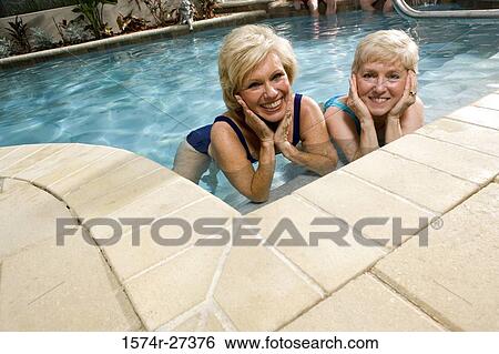 Portrait of cheerful senior women lying in swimming pool View Large Photo Image Stock Photograph - Portrait of cheerful senior women lying in swimming pool. Fotosearch