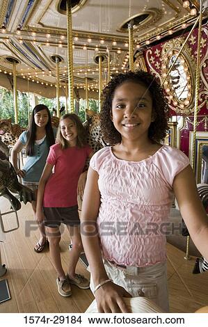 Portrait of cheerful teenage girls standing in a carousel by a carousel leopard View Large Photo Image Picture - Portrait of cheerful teenage girls standing in a carousel by a carousel leopard. Fotosearch