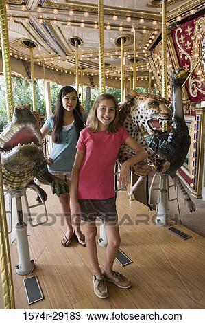 Portrait of cheerful teenage girls standing in a carousel View Large Photo Image Stock Image - Portrait of cheerful teenage girls standing in a carousel. Fotosearch