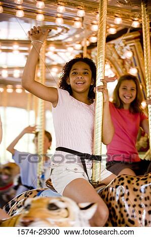Portrait of cheerful teenage girls sitting on a carousel and waving hands View Large Photo Image Stock Image - Portrait of cheerful teenage girls sitting on a carousel and waving hands. Fotosearch