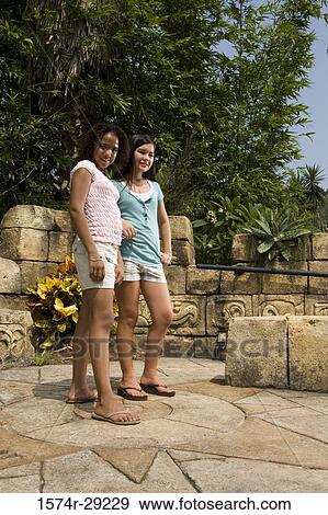 Portrait of cheerful teenage girls standing together with trees in the background View Large Photo Image Stock Photo - Portrait of cheerful teenage girls standing together with trees in the background. Fotosearch