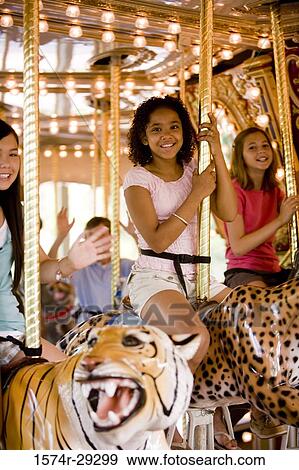 Portrait of cheerful teenage girls sitting on a carousel View Large Photo Image Stock Photo - Portrait of cheerful teenage girls sitting on a carousel. Fotosearch