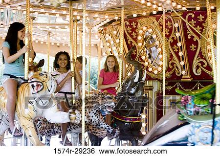 Portrait of cheerful teenage girls sitting on a carousel View Large Photo Image Stock Photograph - Portrait of cheerful teenage girls sitting on a carousel. Fotosearch