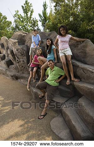 Portrait of cheerful teenagers sitting on the rocks View Large Photo Image Stock Photo - Portrait of cheerful teenagers sitting on the rocks. Fotosearch