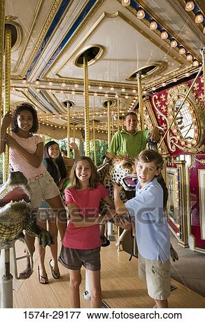 Portrait of cheerful teenagers standing in a carousel View Large Photo Image Stock Photo - Portrait of cheerful teenagers standing in a carousel. Fotosearch