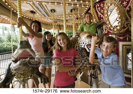 Portrait of cheerful teenagers standing in a carousel View Large Photo Image Stock Photograph - Portrait of cheerful teenagers standing in a carousel. Fotosearch