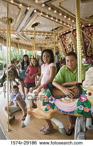 Portrait of cheerful teenagers standing in a carousel View Large Photo Image Stock Photograph - Portrait of cheerful teenagers standing in a carousel. Fotosearch