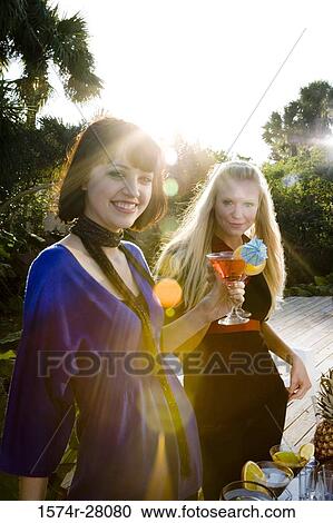 Portrait of cheerful women holding wineglasses on wooden deck View Large Photo Image Stock Image - Portrait of cheerful women holding wineglasses on wooden deck. Fotosearch