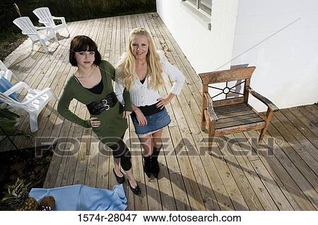 Portrait of cheerful women standing on wooden deck View Large Photo Image Stock Photo - Portrait of cheerful women standing on wooden deck. Fotosearch
