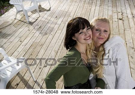 Portrait of cheerful women standing face to face on wooden deck View Large Photo Image Stock Photo - Portrait of cheerful women standing face to face on wooden deck. Fotosearch