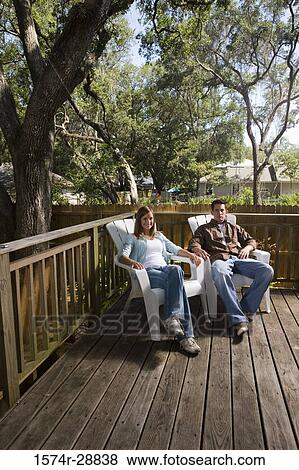 Portrait of cheerful young couple relaxing on armchairs View Large Photo Image Stock Photo - Portrait of cheerful young couple relaxing on armchairs. Fotosearch