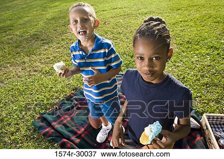 Portrait of children with pastries standing on blanket at park View Large Photo Image Stock Photo - Portrait of children with pastries standing on blanket at park. Fotosearch