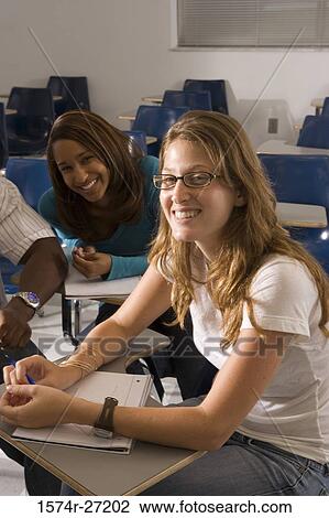 Stock Image - Portrait of female students smiling in the classroom. Fotosearch