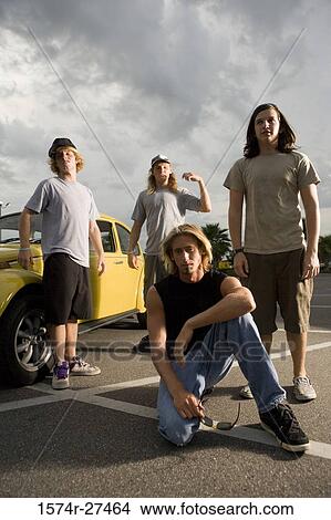 Picture - Portrait of friends by a car at the parking area. Fotosearch