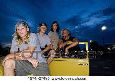Stock Photography - Portrait of friends by a car at the parking area. Fotosearch