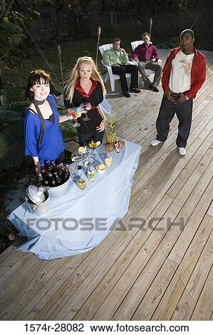 Stock Image - Portrait of friends on wooden deck. Fotosearch