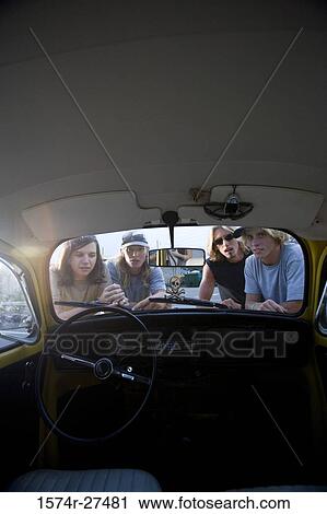 Portrait of friends peeping in a car View Large Photo Image Stock Image - Portrait of friends peeping in a car. Fotosearch