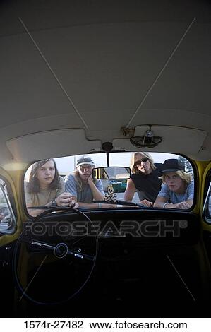 Portrait of friends peeping in a car View Large Photo Image Stock Image - Portrait of friends peeping in a car. Fotosearch
