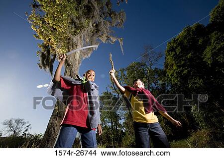 Portrait of friends playing with sword and stick at forest View Large Photo Image Picture - Portrait of friends playing with sword and stick at forest. Fotosearch