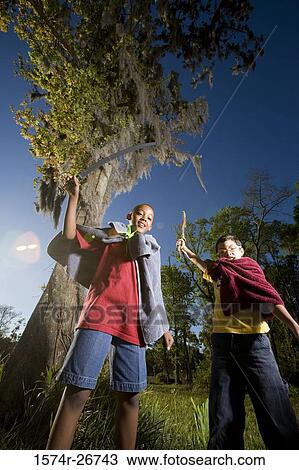 Portrait of friends playing with sword and stick at forest View Large Photo Image Stock Image - Portrait of friends playing with sword and stick at forest. Fotosearch