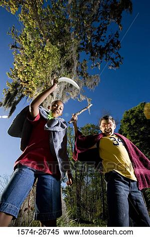 Portrait of friends playing with sword and stick at forest View Large Photo Image Stock Photography - Portrait of friends playing with sword and stick at forest. Fotosearch
